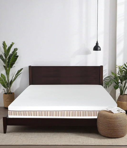 Venti two sided organic latex mattress shown without sheets on a tosca wood bed frame in a minimalist bedroom featuring beautiful palm trees.