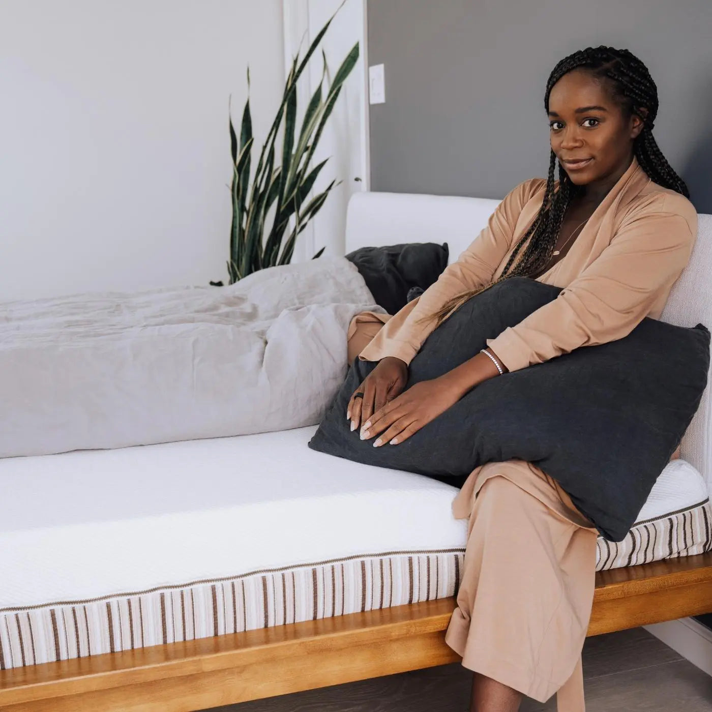 Beautiful actress Aja Naomi King lounging on her Essentia organic mattress